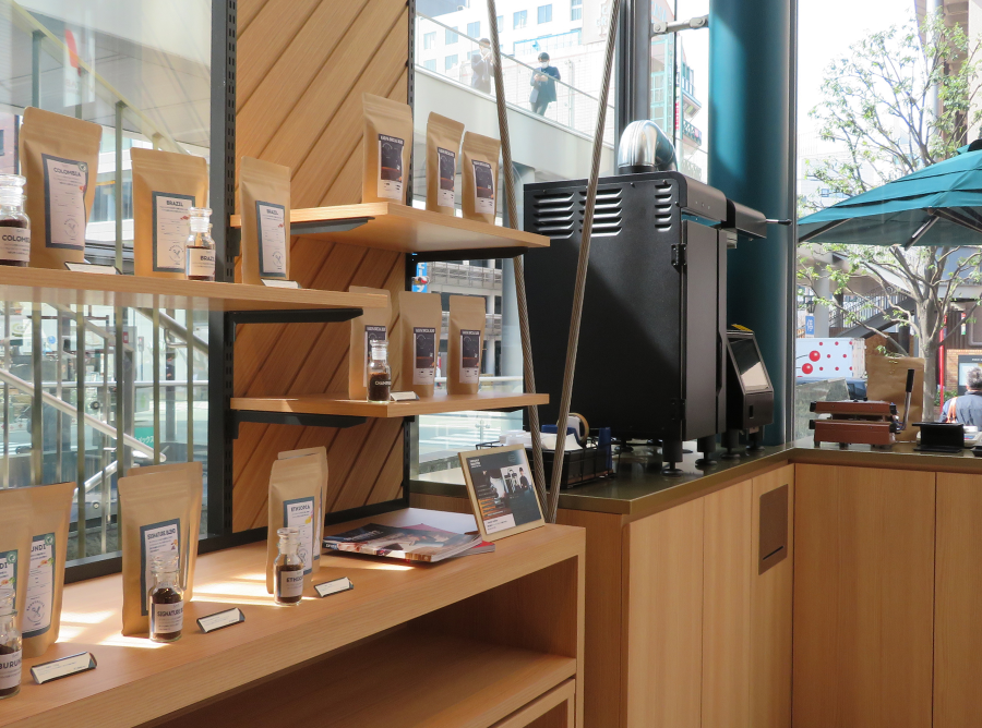 Inside a coffee shop, shelves display an array of coffee and related items, creating an inviting atmosphere.