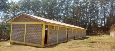 "A building with yellow trim surrounded by trees, located in the Ethiopia Sidamo region. "