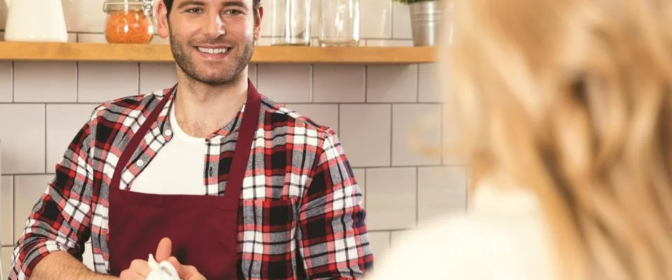 A man and woman are engaged in conversation in a cozy kitchen setting