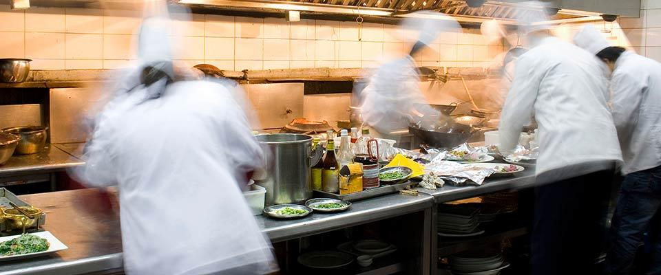 Chefs working in a busy kitchen, slightly blurred, creating a lively cooking atmosphere.