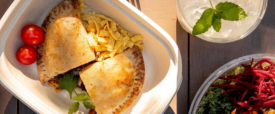 Rethinking Your Menu, savory empanada with tortilla chips and fresh tomato on a tray.