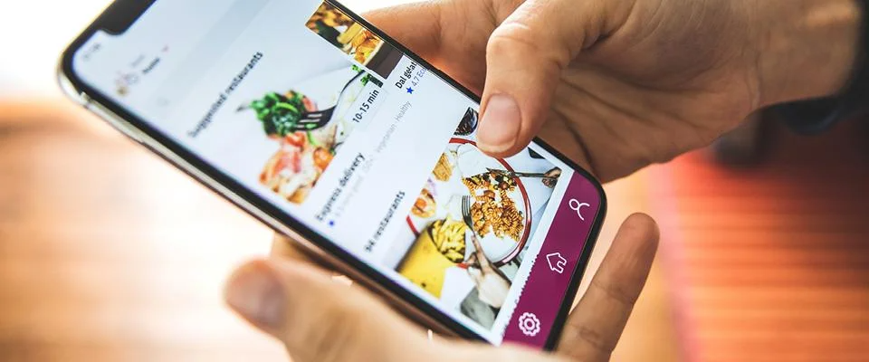 Thinking Like a Startup, person using food delivery app on smartphone screen.