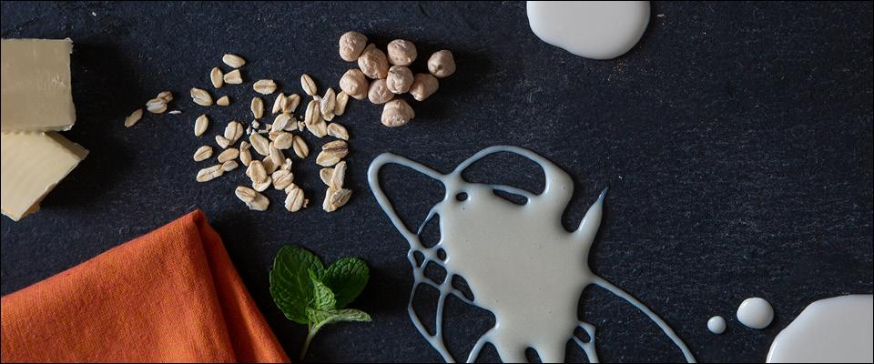 A bowl filled with assorted nuts, milk, and spices elegantly arranged on a wooden table.