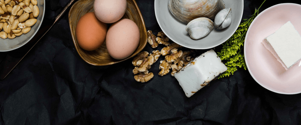 A diverse assortment of food items featuring eggs, mushrooms, and various types of nuts arranged attractively.