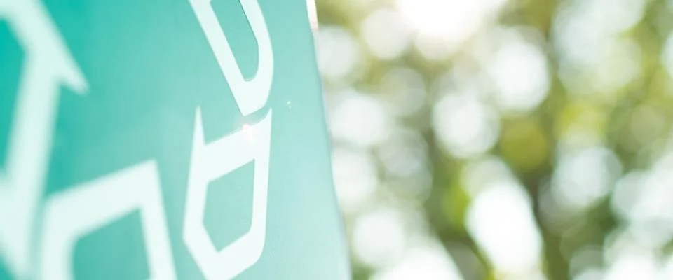 Close-up of a green sign displaying some bold letters.