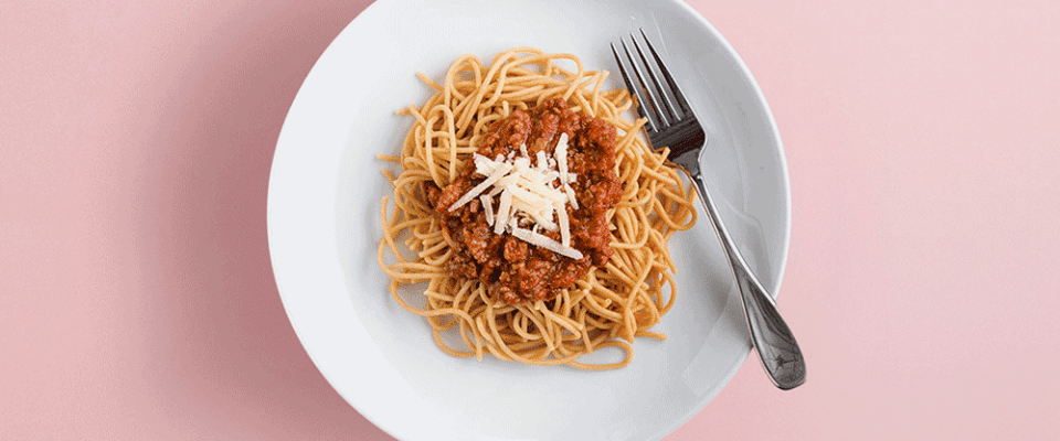 A plate of pasta with bolognese sauce and cheese, highlighting portion awareness.