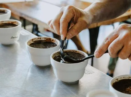A person is serving coffee by pouring it into cups on a table, adding a cozy touch to the setting.