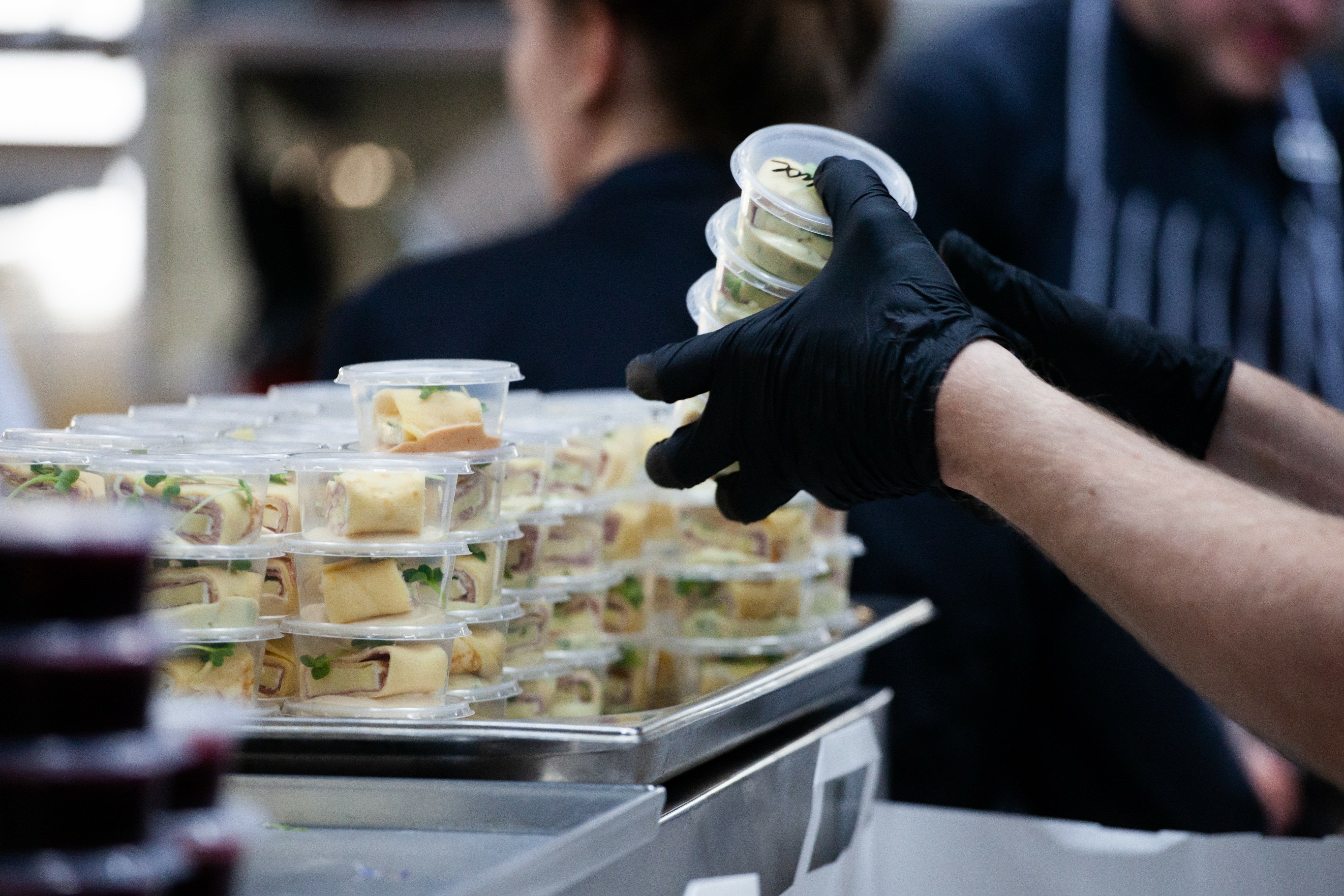 A chef places food into containers, emphasizing the importance of managing food allergens.