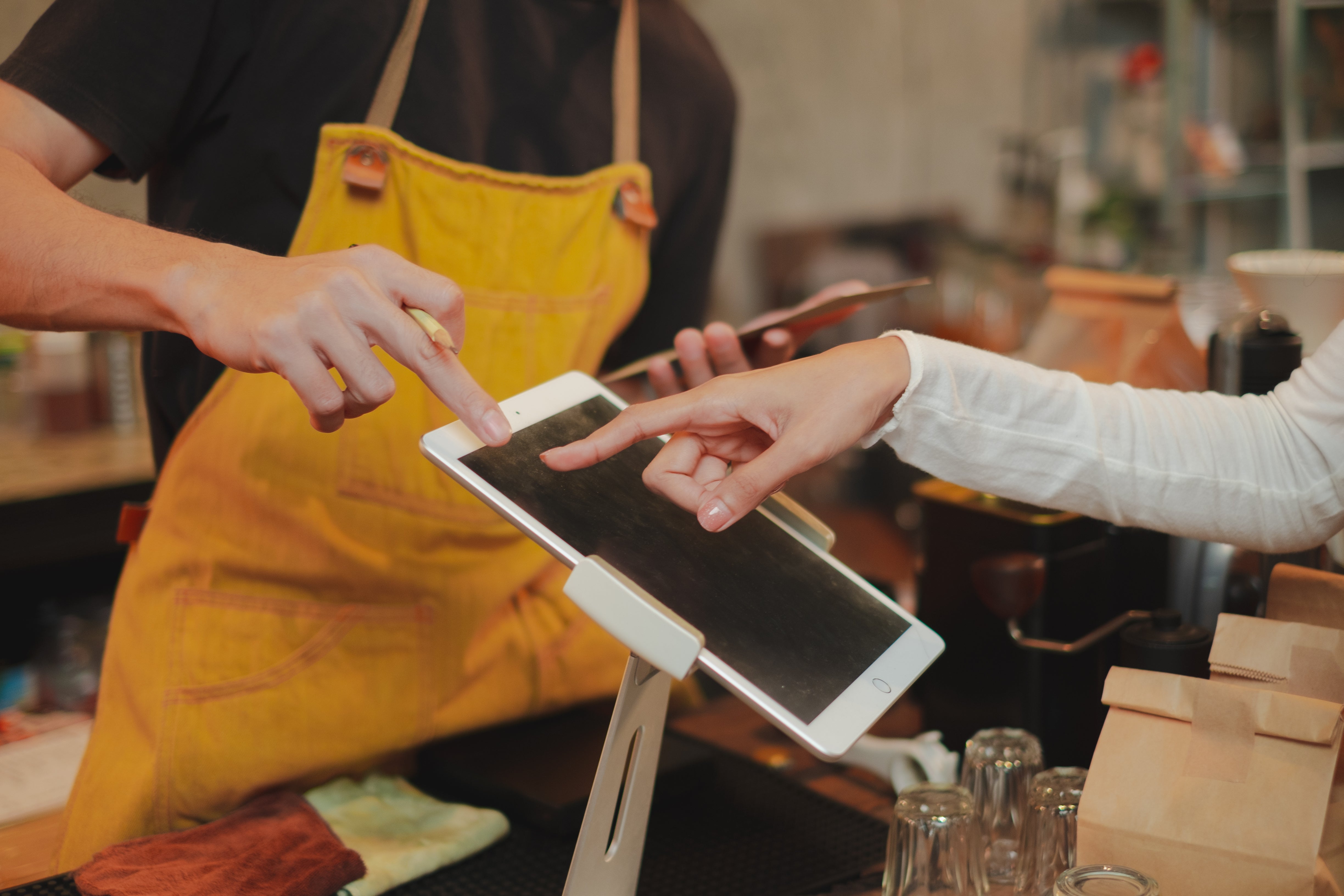 A couple is focused on a tablet, making a purchase together.