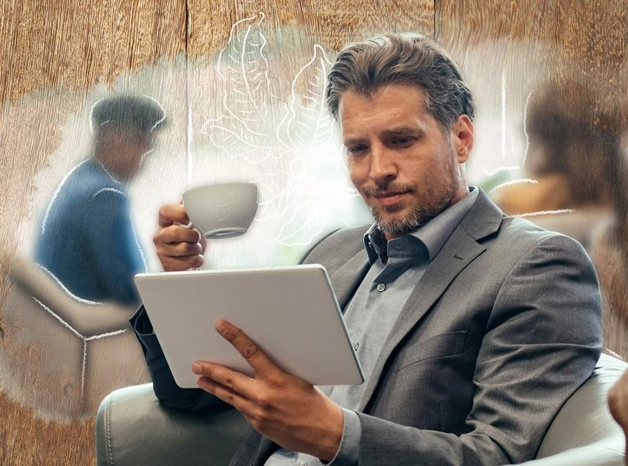 A man in a suit is focused on using a tablet computer in a professional setting.