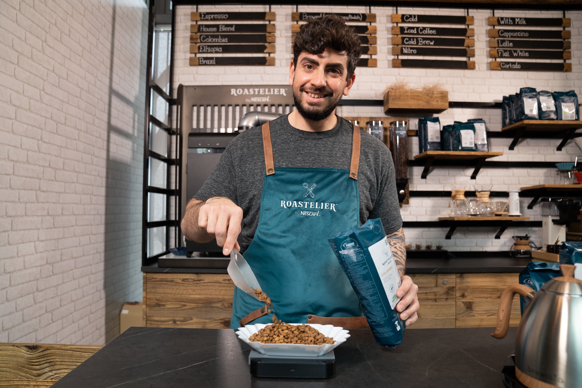 A man smiles while holding a bowl of food, ready to serve a delicious meal.