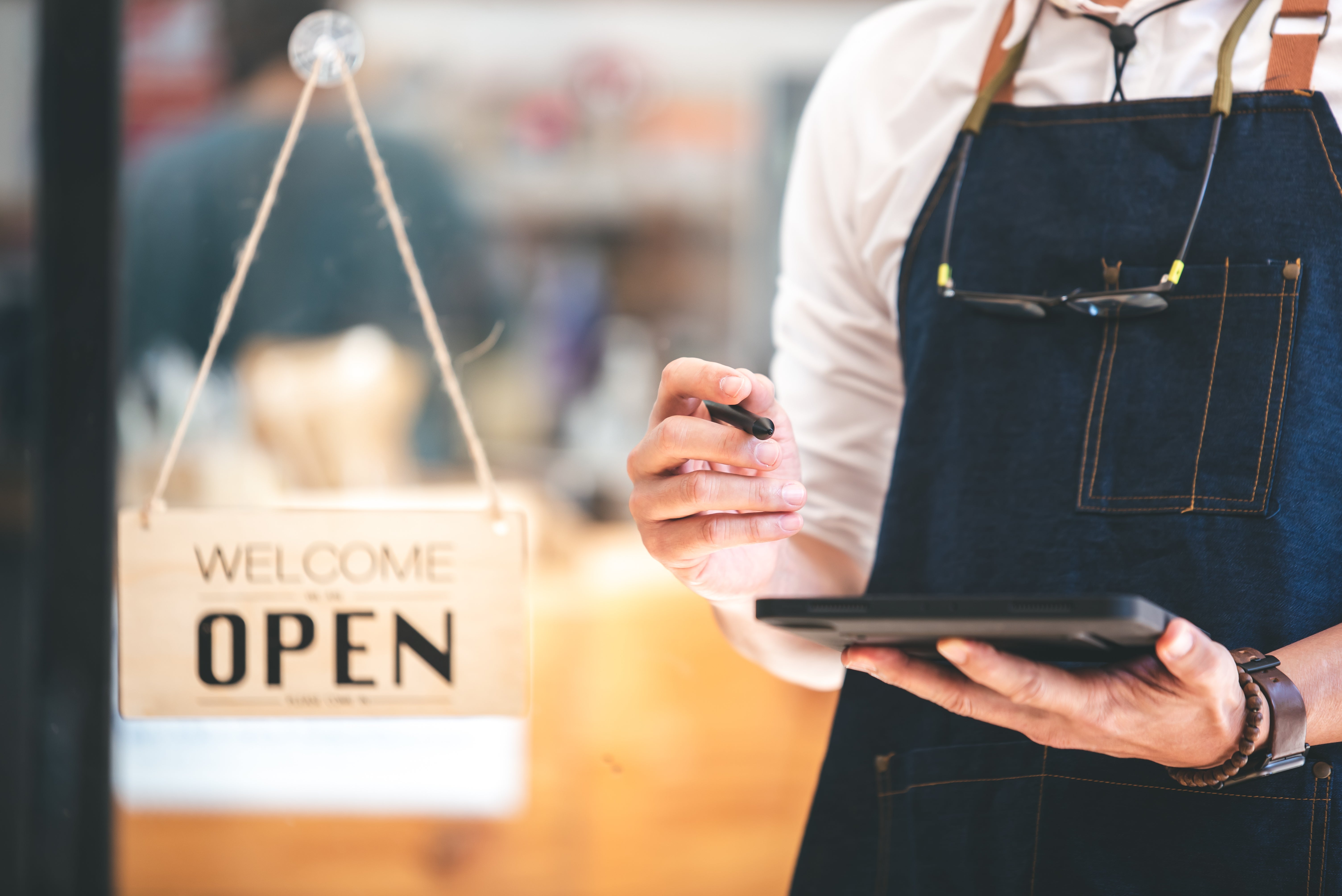 A business owner uses a tablet to prepare for opening their shop.