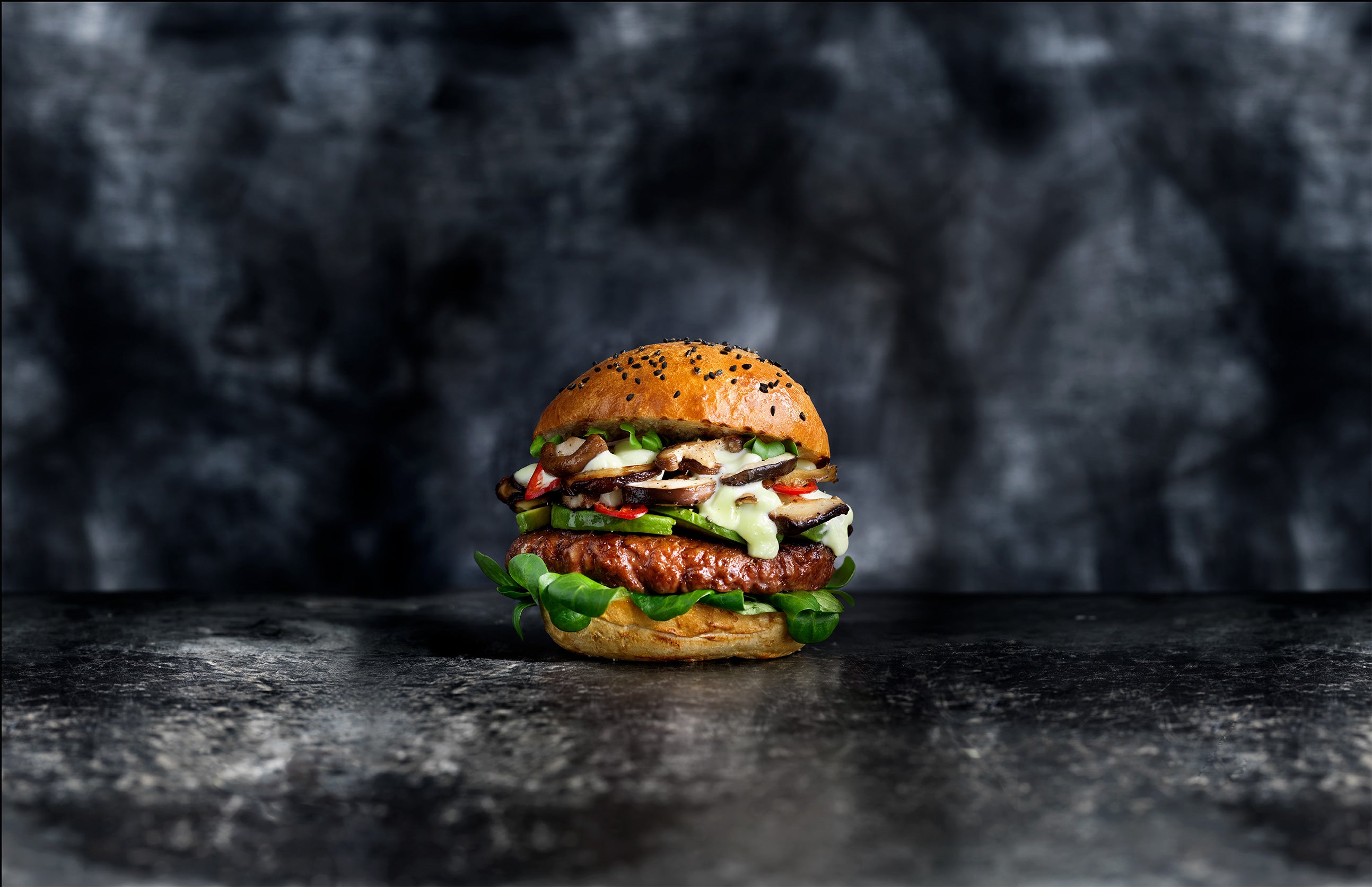 A delicious plant-based burger with vegetables, served in a sesame seed bun.