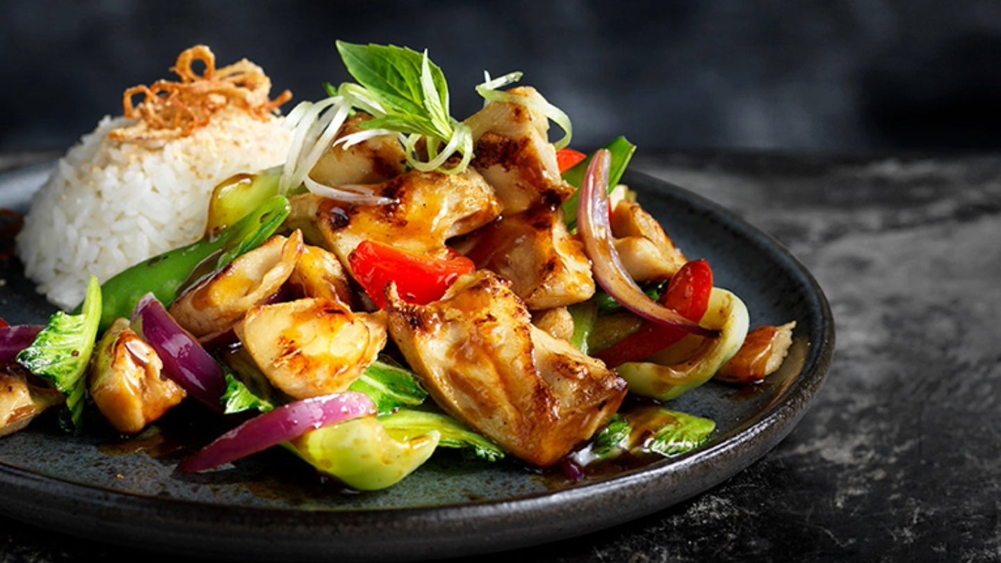 A plate featuring a serving of chicken accompanied by colorful vegetables and a portion of rice.