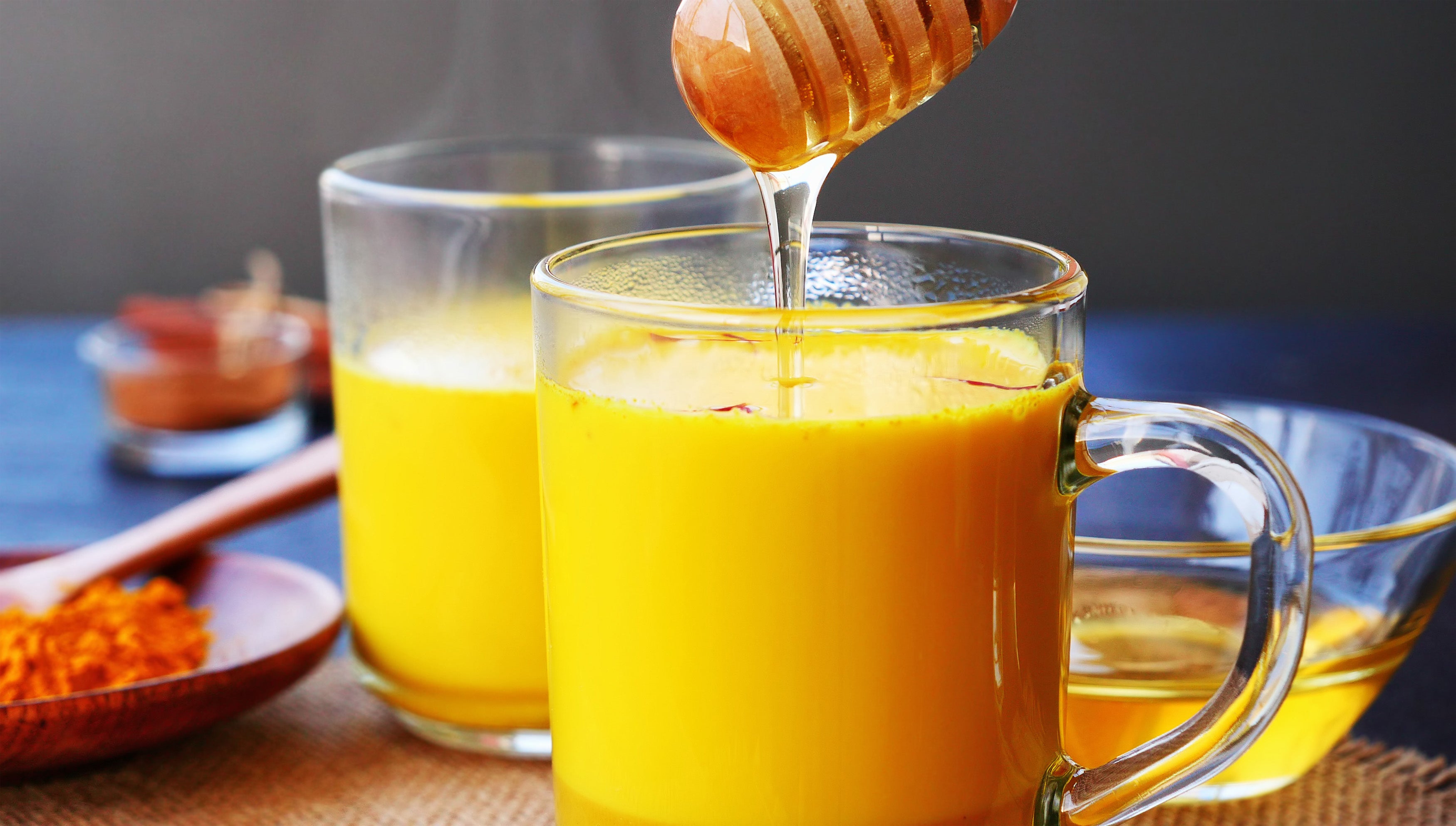 A small bowl of tumeric and honey on a rustic table, showcasing their popularity in food services for well-being