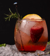 Cocktail with strawberries and rosemary, served on ice for a delightful drink.