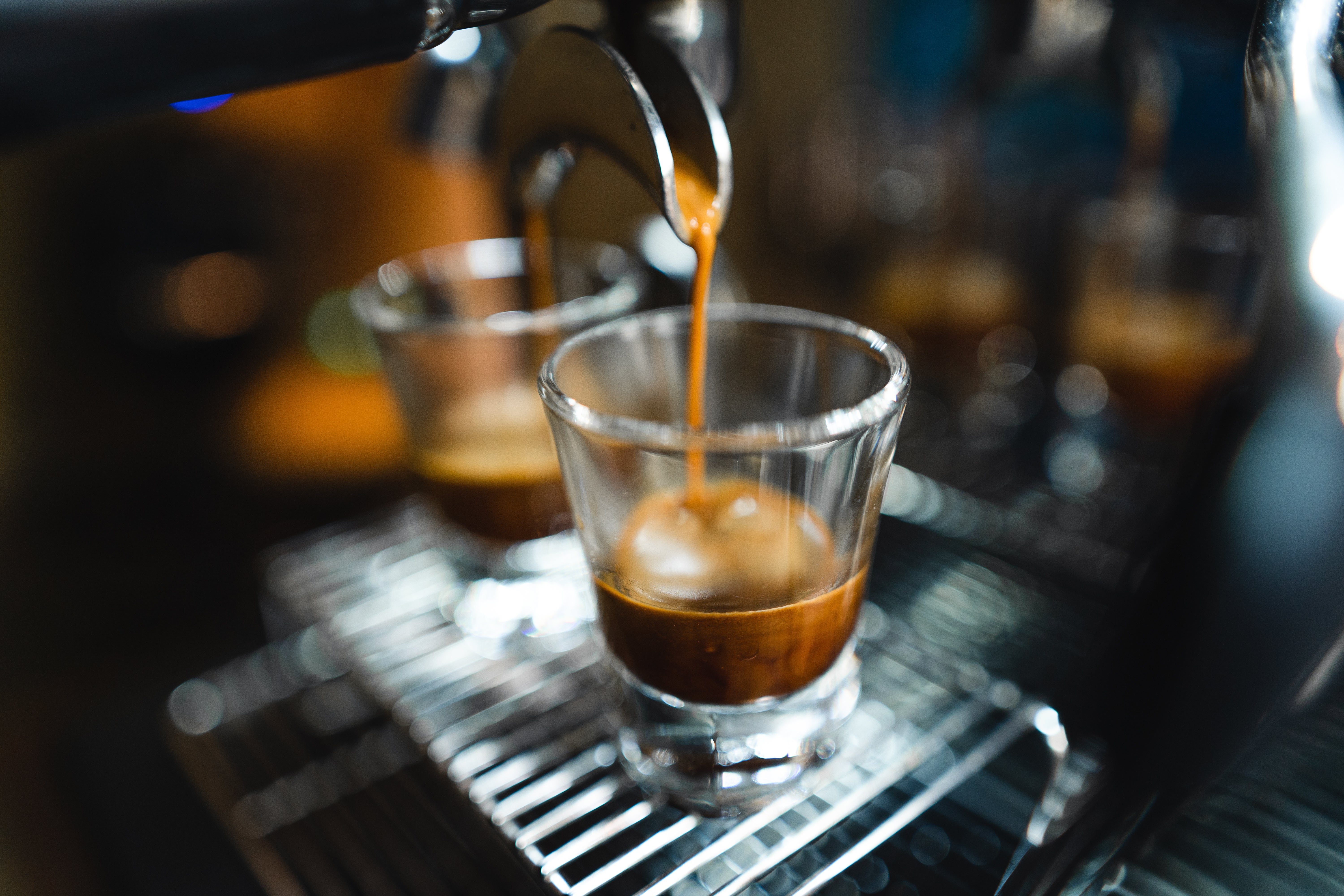 Espresso machine pouring coffee into a clear glass.