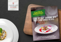 A book lies open on a table next to a plate of food, creating a cozy reading and dining scene.