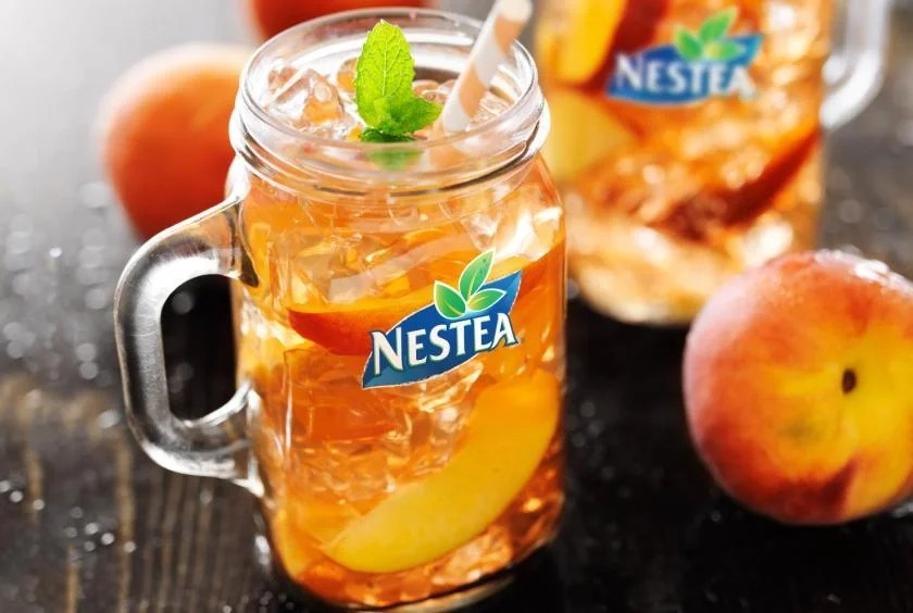 Nestea peach tea bottle, showcasing a bright label adorned with peaches, indicating a fruity, refreshing beverage.