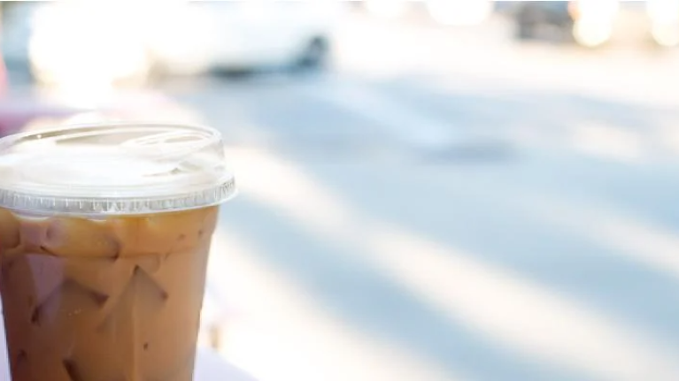 A close-up of an iced coffee in a takeout cup, showcasing how to handle beverages.