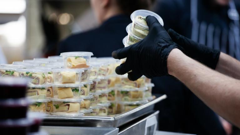 A chef places food into containers, emphasizing the importance of managing food allergens.