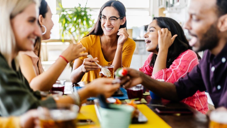Group of Gen Z people enjoying coffee in a café