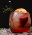 Cocktail with strawberries and rosemary, served on ice for a delightful drink.