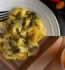 A plate of pasta with fresh broccoli and ripe tomatoes, creating a colorful and appetizing dish.