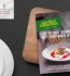 A book lies open on a table next to a plate of food, creating a cozy reading and dining scene.