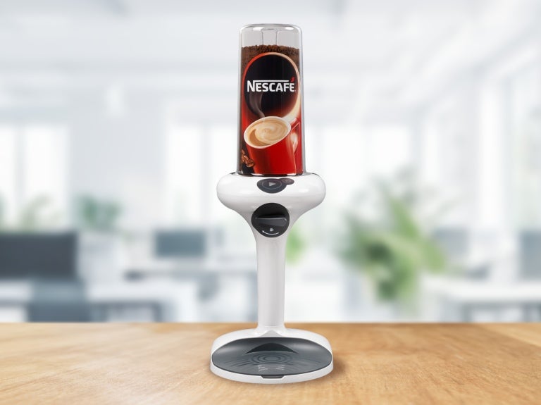 A coffee machine with a steaming cup of coffee placed on top, showcasing its sleek design and functionality.