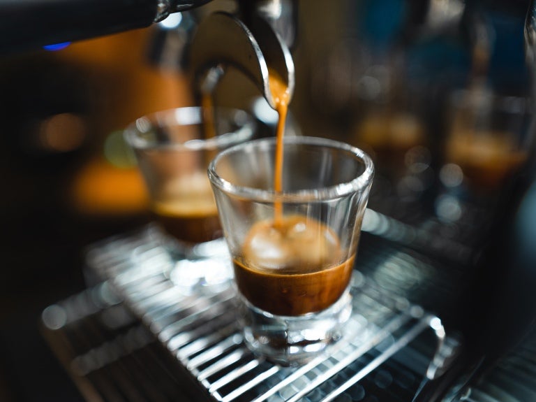 Espresso machine pouring coffee into a clear glass.