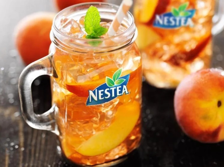 Nestea peach tea bottle, showcasing a bright label adorned with peaches, indicating a fruity, refreshing beverage.