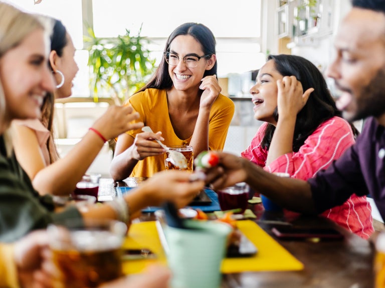 Group of Gen Z people enjoying coffee in a café