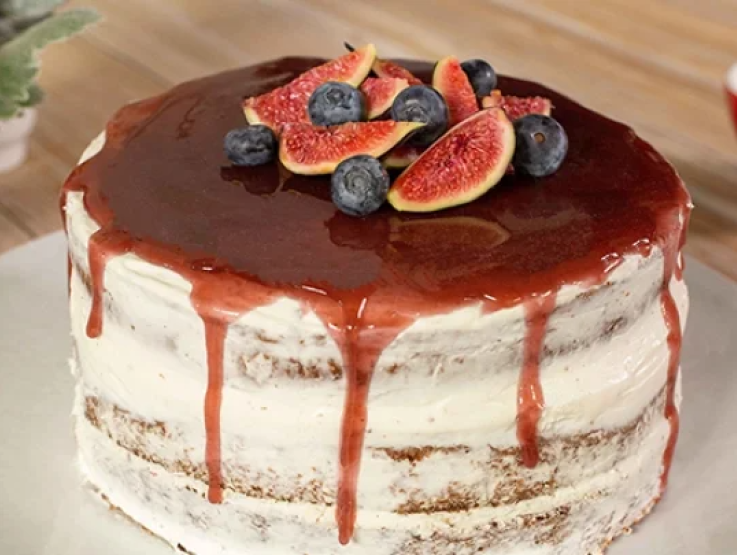 A cake featuring ripe figs and juicy blueberries on top, perfect for any celebration.