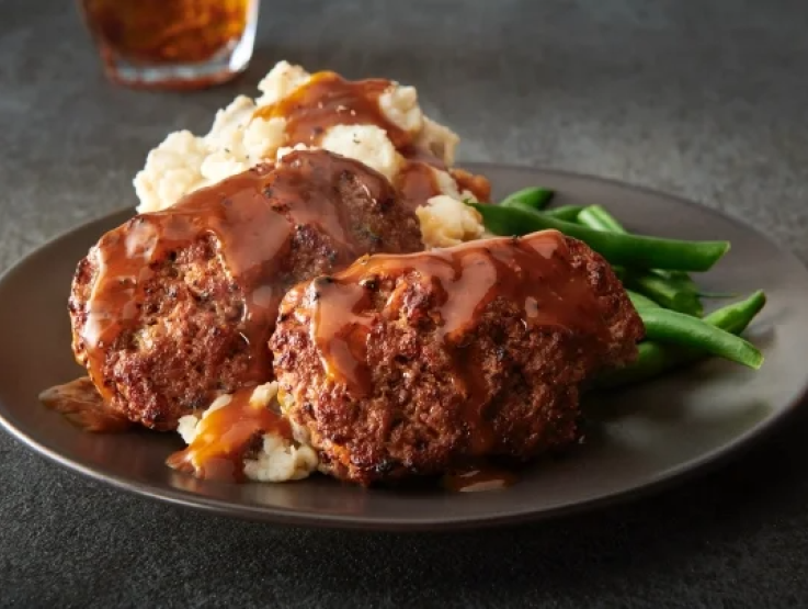 A delicious meal of meatloaf served with fluffy mashed potatoes on a white plate.