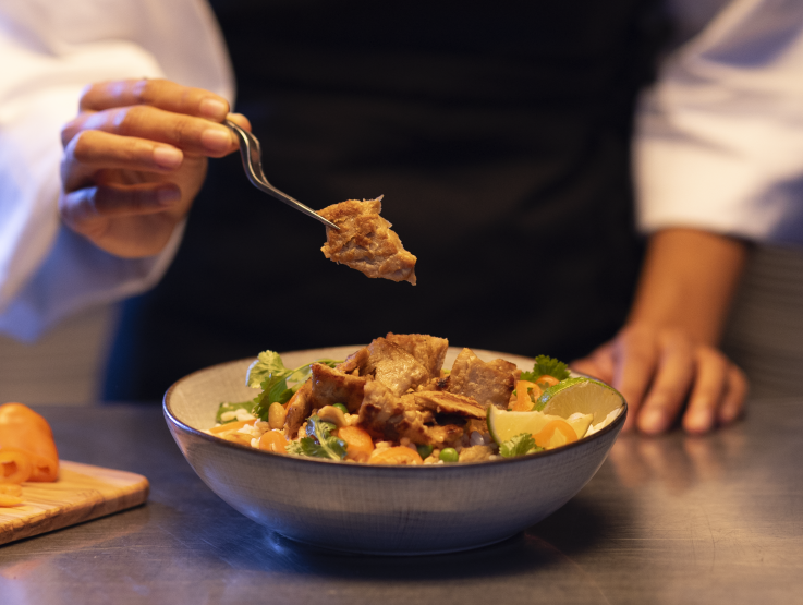 Chef with pulled filet dish in a white dish