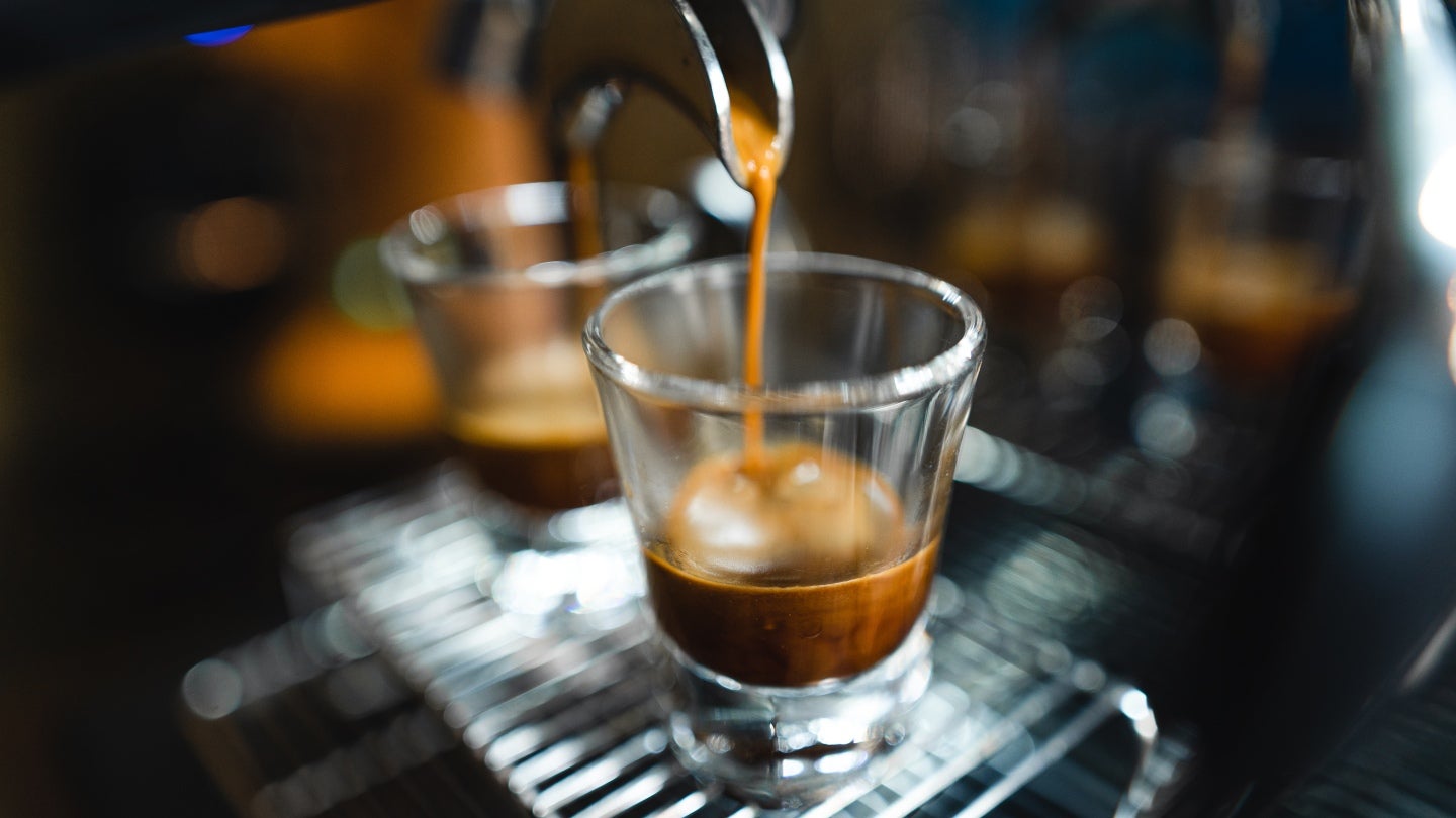 Espresso machine pouring coffee into a clear glass.