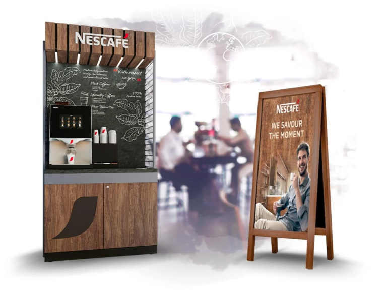 A coffee machine with a sign on it, next to a wall that also has a sign displayed.