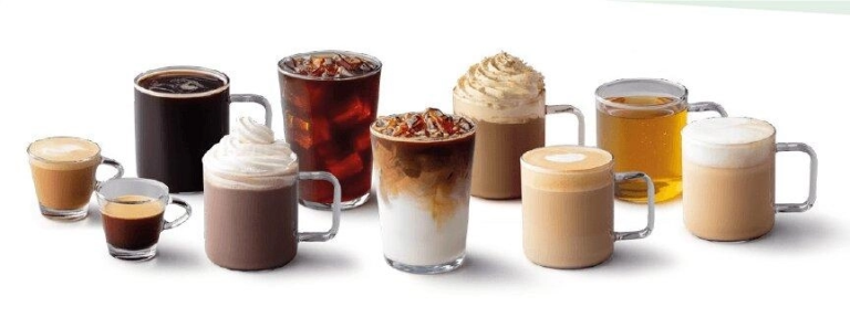 A selection of different coffee drinks, such as lattes and cappuccinos, together on a table.