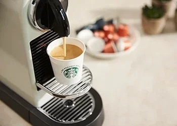 A Starbucks espresso machine and a cup of coffee, highlighting the art of espresso brewing.