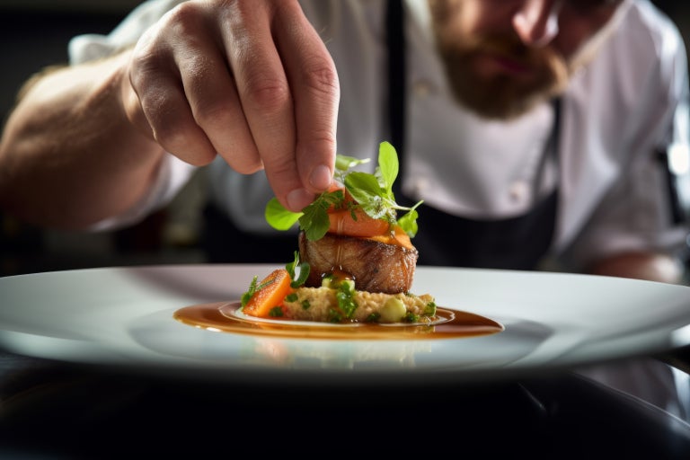Young male chef finalizing a savoury dish